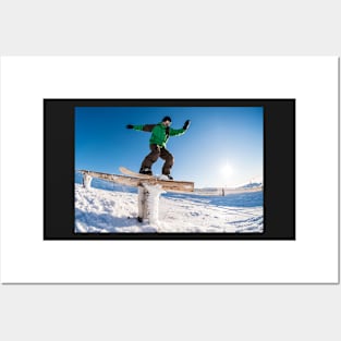 Snowboarder sliding on a rail Posters and Art